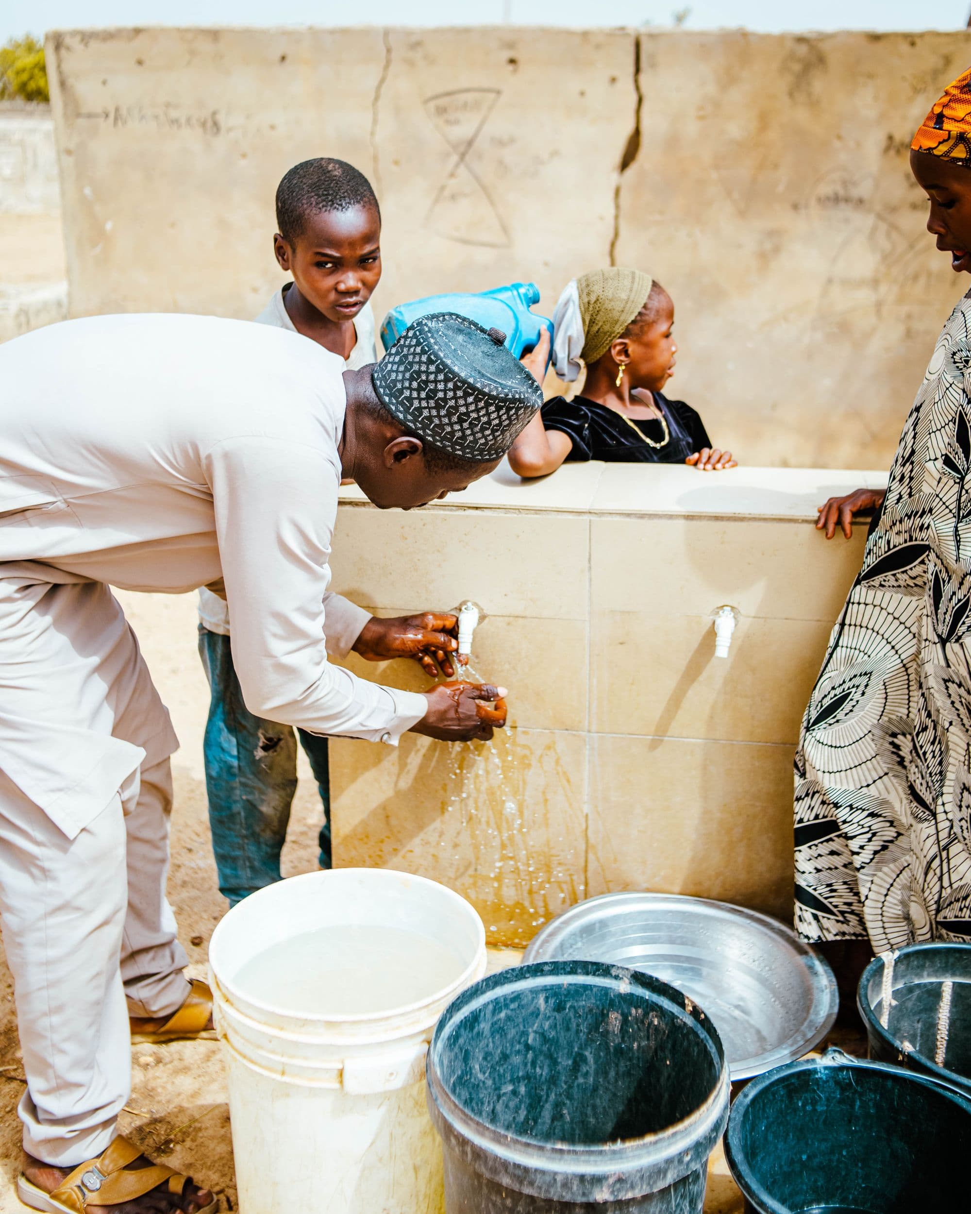 People collecting water from a village tap